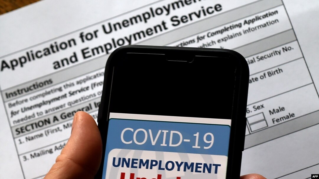 FILE - A COVID-19 Unemployment Assistance Updates logo is displayed on a smartphone against the backdrop of an application for unemployment benefits, in Arlington, Virginia.