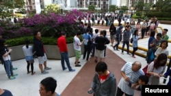 Voters stand in line to vote at a polling station during district council local elections, Hong Kong, Nov. 24, 2019. Voters are turning out in record numbers for an elect seen as a referendum on pro-democracy protests.