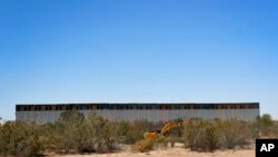 Government contractors erect a section of border wall along the Colorado River, Sept. 10, 2019 in Yuma, Ariz.
