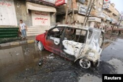 FILE - A man stands by a car damaged by a strike near al-Thawra Hospital in Hodeida, Yemen, Aug. 2, 2018.