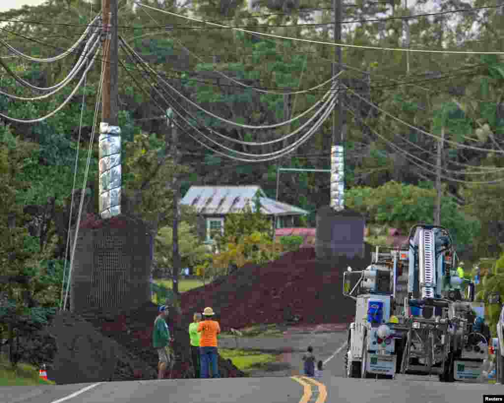 Pekerja konstruksi mempersiapkan jalan desa Pahoa saat aliran lahar dari Gunung Kilauea mendekati desa tersebut (28/10). 