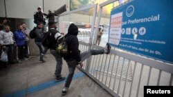 Usuarios del metro intentan abrir una estación del subterráneo de Sao Paulo en Itaquera.