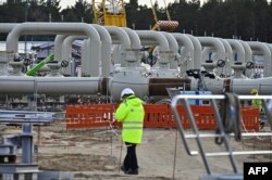 Para pria bekerja di lokasi pembangunan pipa gas Nord Stream 2 di Lubmin, Jerman timur laut, 26 Maret 2019. (Foto: AFP)