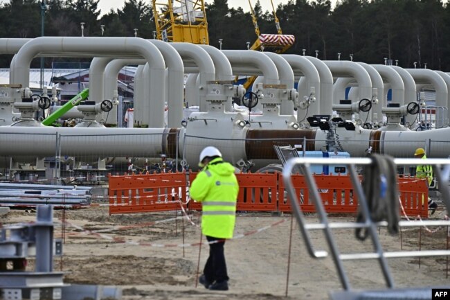 Para pria bekerja di lokasi pembangunan pipa gas Nord Stream 2 di Lubmin, Jerman timur laut, 26 Maret 2019. (Foto: AFP)