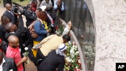 People lay flowers at the U.S. Embassy bombing memorial site in Nairobi, Kenya, Aug. 7, 2013, to mark the 15-year anniversary of the 1998 embassy bombing which killed more than 200 people and injured thousands more.