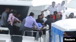 FILE - Officials carry an injured woman off the speed boat of Maldives' President Abdulla Yameen Abdul Gayoom after an explosion onboard, in Male, Sept. 28, 2015. 