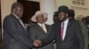 FILE - Former Vice President of South Sudan Riek Machar, left, greets South Sudan President Salva Kiir, right, as Uganda President Yoweri Museveni looks on, July 7, 2018, Uganda. A report released Thursday says Uganda diverted European weapons to South Sudan despite an EU ban.