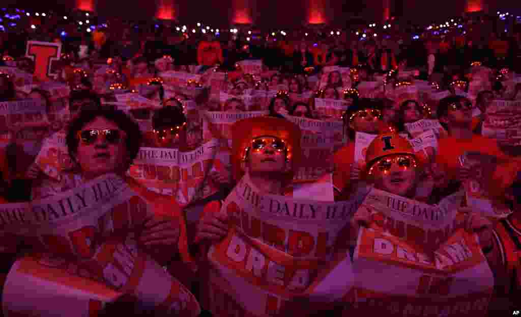 Illinois fans hold mock newspapers with the headline Curdled Dreams in Champaign as the Wisconsin basketball team is introduced at the beginning of an NCAA college basketball game between Illinois and Wisconsin, Dec. 10, 2024, in Champaign, Illinois.