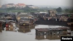 FILE - Makeshift stalls are seen submerged along river Ogun as it overflows its bank near a livestock market outside Nigeria's commercial capital Lagos, Oct. 6, 2016.