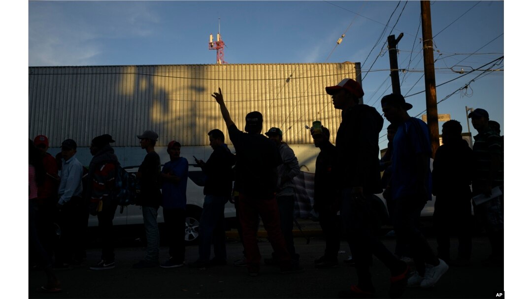 Men line up for dinner outside a shelter housing members of the migrant caravan, in Tijuana, Mexico, Nov. 26, 2018.