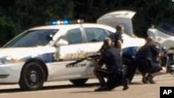 In this image made from video and released by WRCB-TV, authorities work an active shooting scene on Amincola highway near the Naval Reserve Center in Chattanooga, Tennessee, July 16, 2015.