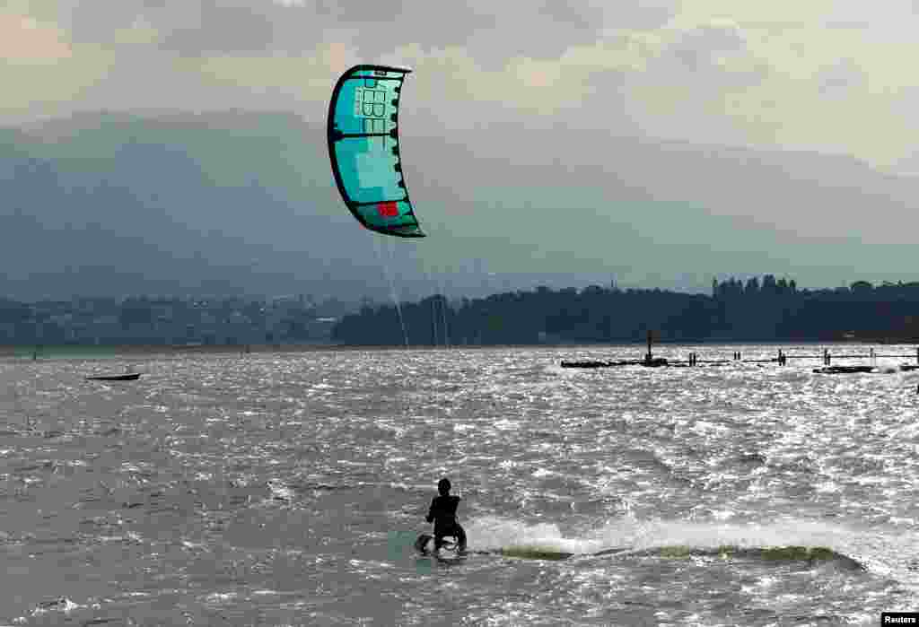 A man kite surfs using a strong northerly wind on Lake Leman in Geneva, Switzerland.