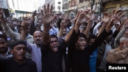 Shi'ite Muslim men shout slogans during a protest rally organised by the religious group Majlis-e- Wahdat-e-Muslimeen (MWM) in Karachi, January 11, 2013, to condemn the bomb blasts in Quetta a day earlier, and the killings of Shiites. 