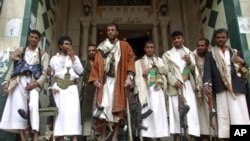 Armed tribesmen loyal to tribal leader Sheikh Sadiq al-Ahmar stand at the entrance of a building near al-Ahmar's house during clashes in Sana'a, May 26, 2011