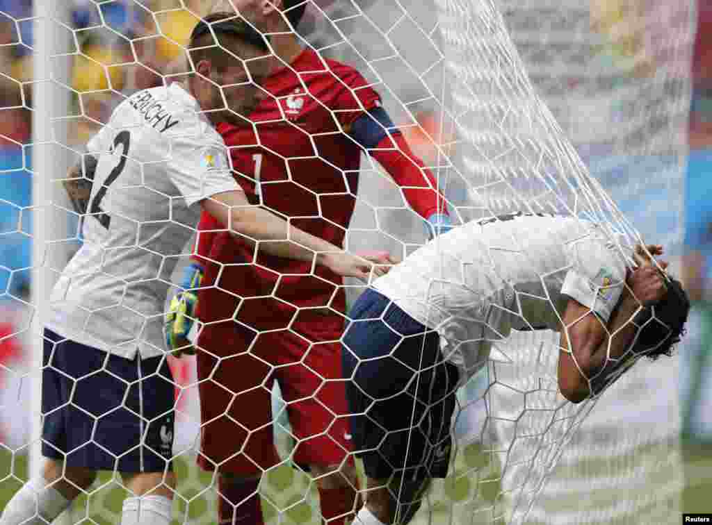 French player Raphael Varane rests on the net after an injury during the match against Nigeria, at the national stadium in Brasilia, June 30, 2014.