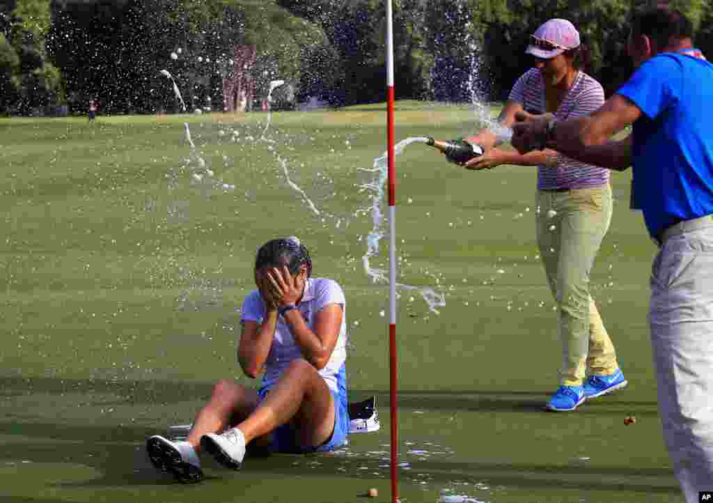 Celine Herbin dari Perancis disiram dengan sampanye ketika memenangkan Turnamen Golf Terbuka, Lacoste Open, untuk kategori putri di Saint Jean de Luz, Perancis barat daya.