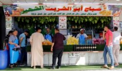 Orang-orang membeli jus kismis untuk berbuka puasa di bulan suci Ramadan di Mosul, Irak, 17 April 2021. (REUTERS/Khalid Al-Mousily)