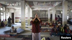 在加德满都，一名藏族妇女在同情西藏的暴力受害者和自焚抗议者的活动中祈祷