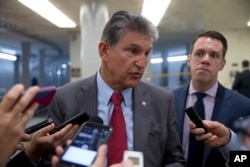 FILE - Sen. Joe Manchin, D-W.Va., talks with reporters on Capitol Hill.