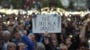 Demonstrators hold a placard reading "Don't sign it, Janos" referring to President Janos Ader as they protest against the amendment of the higher education law seen by many as an action aiming at the closure of the Central European University, founded by Hungarian born American billionaire businessman George Soros, in front of the Parliament building in Budapest, Hungary, April 9, 2017.