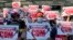 Anti-coup protesters hold posters with "CDM," initials that stand for Civil Disobedience Movement, as they gather outside the Hledan Centre in Yangon, Myanmar, Sunday, Feb. 14, 2021. Daily mass street demonstrations in Myanmar are on their second week, with neither protesters nor