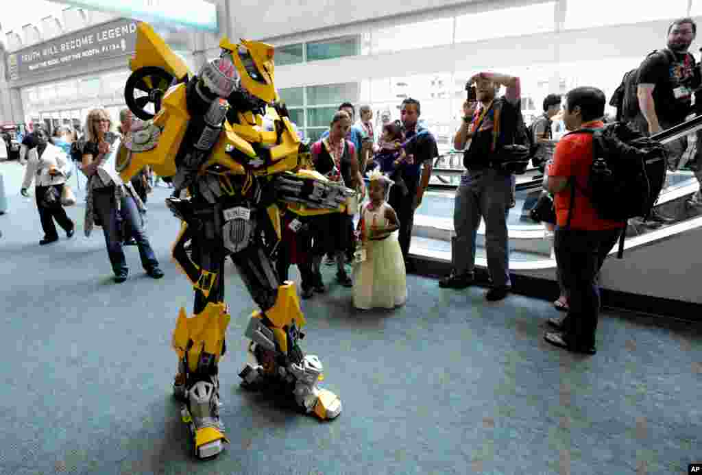 Lionel Lum, dressed as the Transformers' character Bumblebee, poses for photos on the third day of Comic-Con held at the San Diego Convention Center, July 14, 2012, in San Diego.