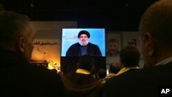 Hezbollah leader Sheikh Hassan Nasrallah speaks via video link to supporters during a ceremony marking the death of six Hezbollah fighters and an Iranian general killed in an Israeli airstrike in Syria’s Golan Heights last week, in the southern suburb of 