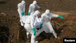 FILE - Health workers carry the body of a suspected Ebola victim for burial at a cemetery in Freetown, Sierra Leone, Dec. 21, 2014. 