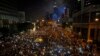 Tens of thousands of pro-democracy demonstrators, some waving lights from mobile phones, fill the streets in the main financial district of Hong Kong, Oct. 1, 2014.