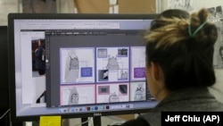 In this Feb. 15, 2018 photo, designer Tiffany Tam shows sketches of a handbag she designed on her computer at a Betabrand store in San Francisco. 