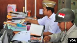 Pegawai Badan Kepegawaian Daerah Pemkot Surabaya mengenakan pakaian pejuang saat masuk kerja (VOA/Petrus Riski).