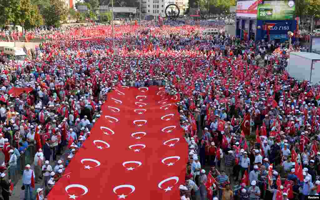 هزاران تن از مظاهره کننده گان در اعتراض به آخرین حملۀ نیروهای کردی در انقره بیرق ترکیه را حمل می کنند.