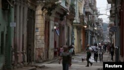 FILE - People walk on a street in Havana, Cuba, April 10, 2019. 