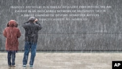 Dos turistas visitan el monumento a Martin Luther King, Jr. en Washington, en medio de una leve nevada.