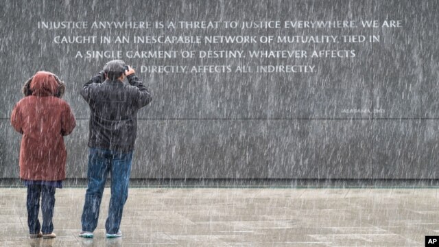 Dos turistas visitan el monumento a Martin Luther King, Jr. en Washington, en medio de una leve nevada.