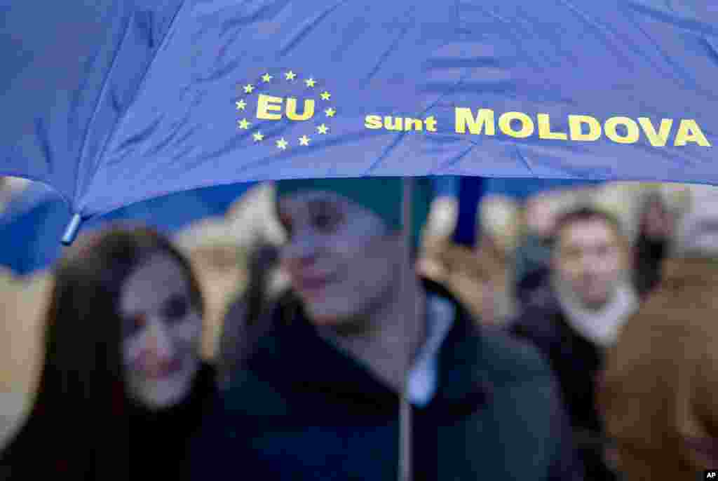 Moldovan students hold an umbrella that uses the European Union symbol to form the sentence &quot;I am Moldova&quot; after arriving in the Romanian capital to vote, at the main railway station, Gara de Nord, in Bucharest, Romania, Sunday, Nov. 30, 2014.