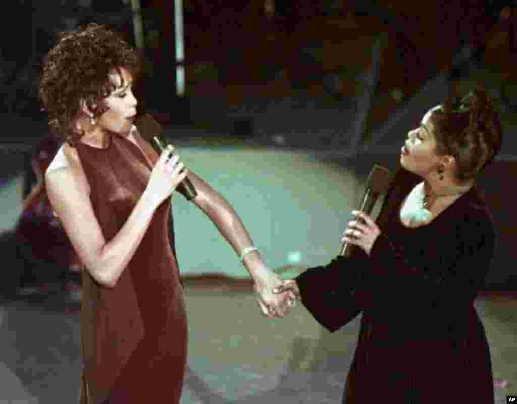 Whitney Houston, left, and CeCe Winans perform a duet at the 38th annual Grammy Awards at the Shrine Auditorium in Los Angeles, Wednesday, Feb. 28, 1996. (AP Photo/Eric Draper)