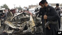 Seorang polisi Afghanistan berdiri di pagar Cure Hospital setelah tiga orang Amerika tewas, Kabul, 24 April 2014.