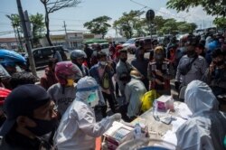 Sejumlah pengendara motor menjalani tes usap (swab) COVID-19 di pos pemeriksaan di Surabay, Minggu, 6 Juni 2021. (Foto: Juni Kriswanto/AFP)