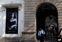 A man walks in front of a Nirav Modi jewelry boutique, that displays a black and white photograph of Bollywood actress Priyanka Chopra in Mumbai, India, Feb. 15, 2018.