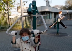 Penzioneri sa zaštitnim maskama u dozvoljenoj šetnji tokom trajanja zabrane kretanja za ostale kategorije stanovništva, u sklopu borbe protiv širenja zaraze koronavirusom, u Beogradu, Srbija, 24. aprila 2020. (AP Photo/Darko Vojinović)