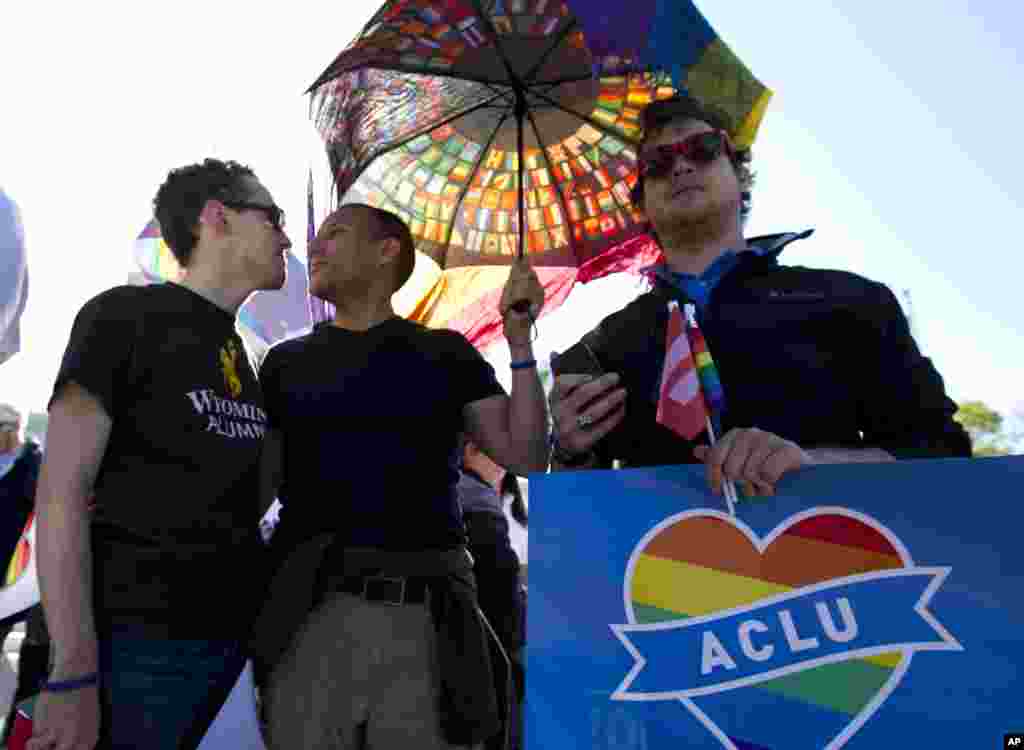 From left; Adam Boyd, Oscar Soto, and Tyler Cargill participate in a demonstration in front of the Supreme Court in Washington, April 28, 2015.