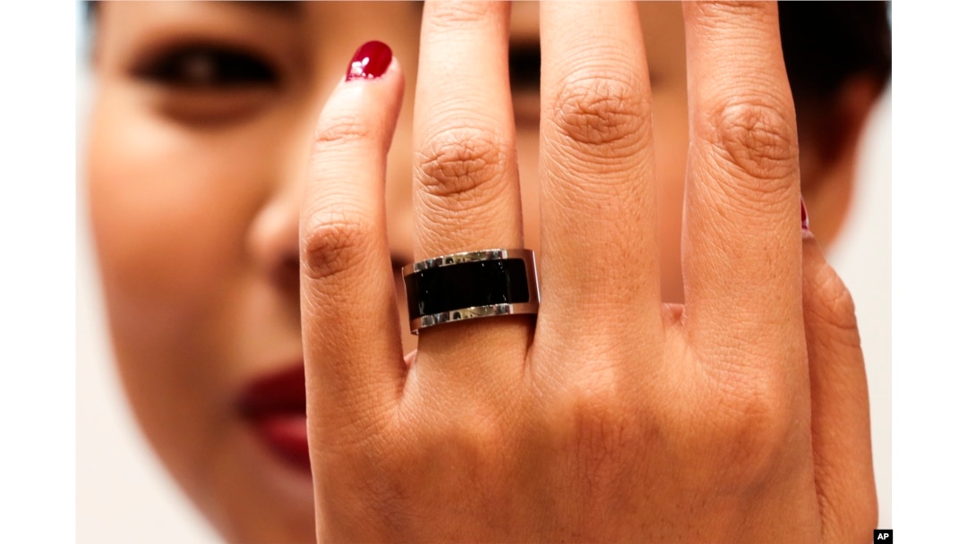 FILE - A woman shows a prototype of the Mota Smart Ring at the consumer electronic fair IFA in Berlin, Germany, Sept. 5, 2014. The smart ring is designed to notify users about incoming messages and phone calls, something, experts say, can be used to cheat on exams.