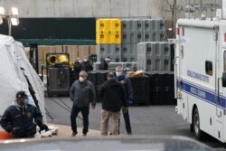 Anggota Kantor Pemeriksa Medis Kota New York di lokasi yang dijadikan fasilitas pemulasaran darurat di luar Rumah Sakit Bellevue untuk menampung lonjakan korba virus corona, di New York, 25 Maret 2020.