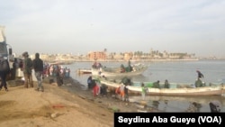 Des pêcheurs déchargent leurs pirogues à Guet Ndar, au Sénégal, le 4 février 2018. (VOA/Seydina Aba Gueye)