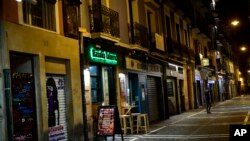Una persona recorre la calle San Nicolás, que aparece inusualmente desierta, en Pamplona, norte de España, ante la emergencia suscitada por la propagación del coronavirus, el viernes 13 de marzo de 2020. España puso en cuarentena a todo el país el domingo 15 de marzo.