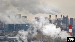 FILE - An aerial view of Moscow, with steam and smoke rising cooling towers and chimneys of a coal-fired power plant in the foreground.