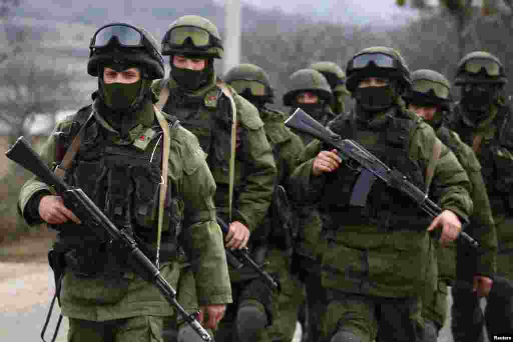 Armed men, believed to be Russian servicemen, march outside an Ukrainian military base in the village of Perevalnoye near the Crimean city of Simferopol, March 9, 2014.&nbsp;
