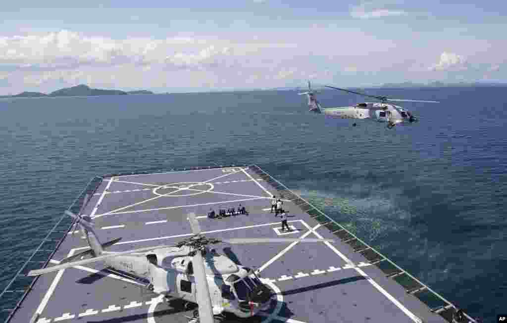 A helicopter takes off from the HTMS Angthonga helipad before a patrol demonstration to the media on a Thai naval ship in Phuket province, May 29, 2015.