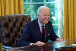 Presiden Joe Biden tersenyum setelah menandatangani perintah eksekutif yang memperkuat akses ke perawatan kesehatan yang terjangkau. (Foto: Reuters/Kevin Lamarque)